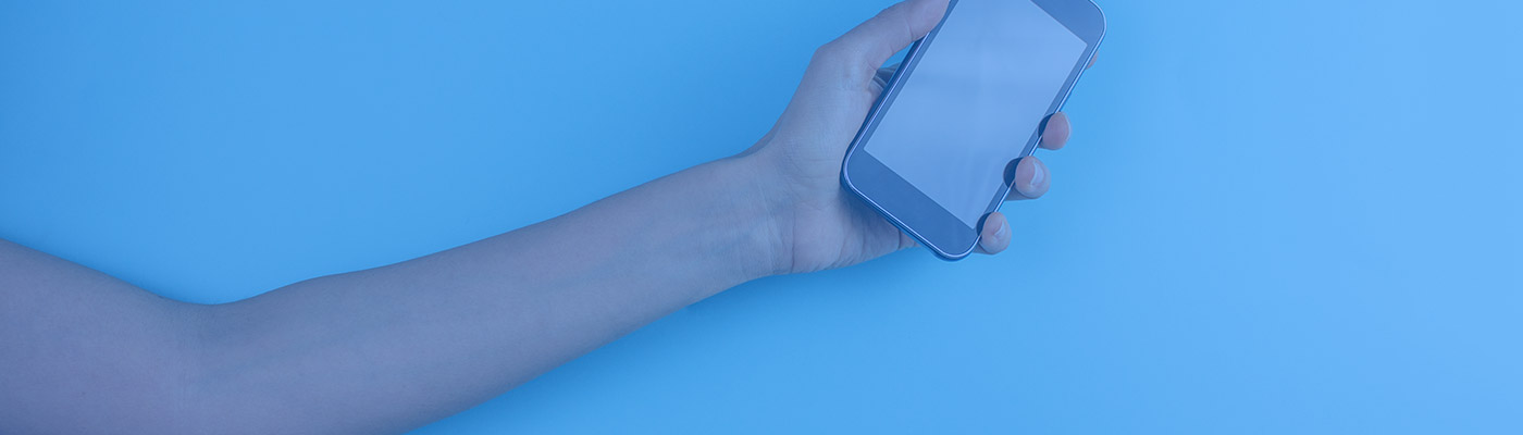 Arm extended holding a smartphone in its hand, with a blue filter overlay.