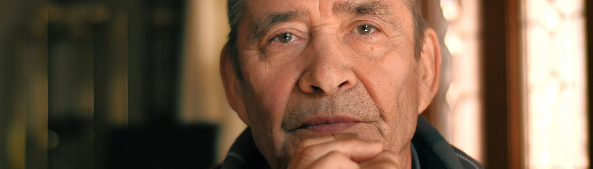 Hispanic man staring into the camera with a serious, concerned stare