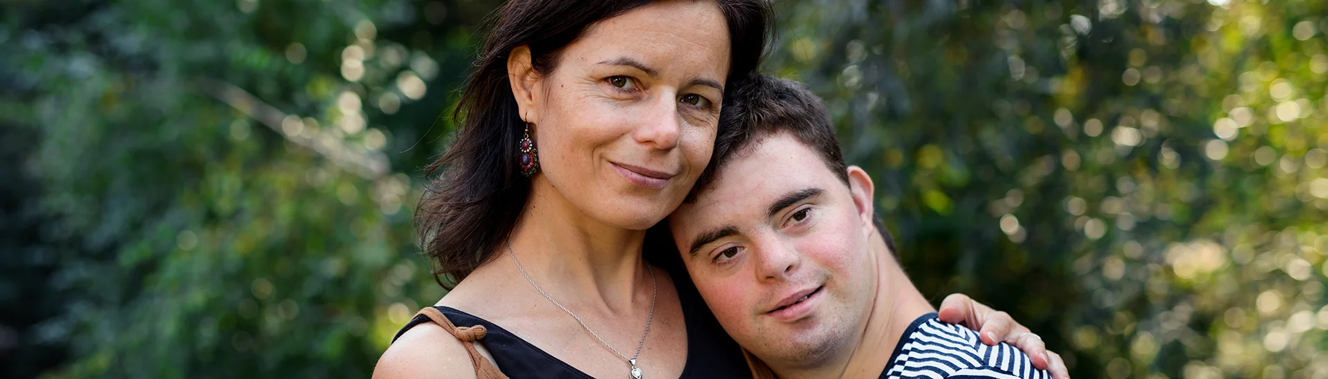 Older man with downs syndrome hugging older woman