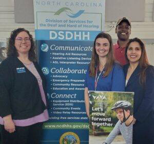 Vaya employees standing next to informational posters at an event