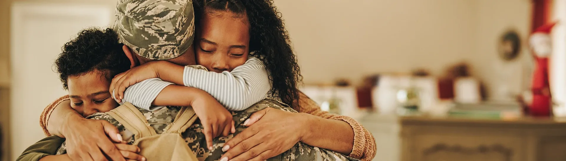 A male soldier in a warm embrace with his two children is welcomed home from deployment.