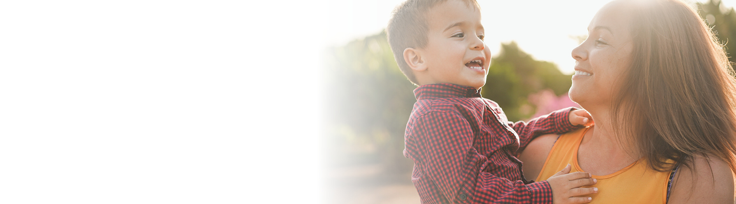 Vaya Total Care Perks Banner - Mujer con su hijo en brazos, ambos sonríen.