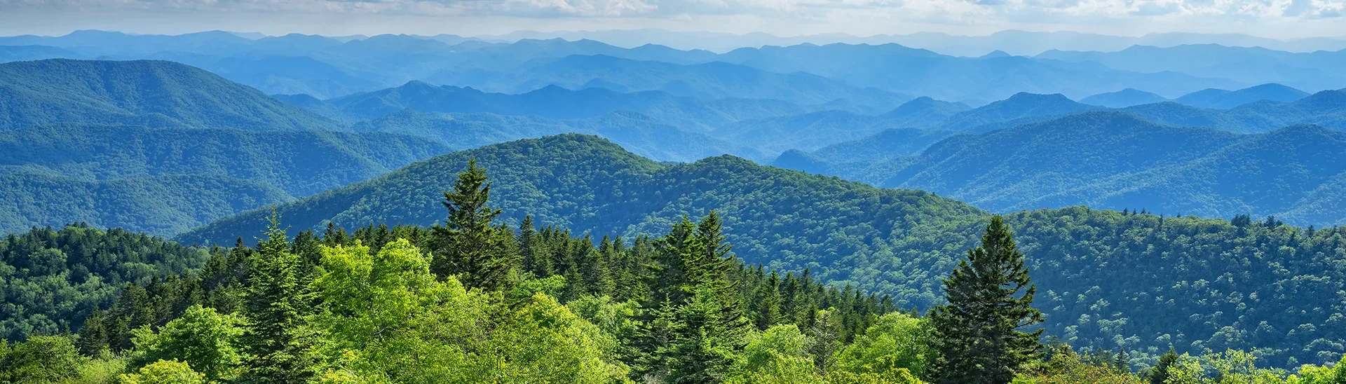 Blue Ridge Mountains in North Carolina landscape view of rolling hills with trees on top.