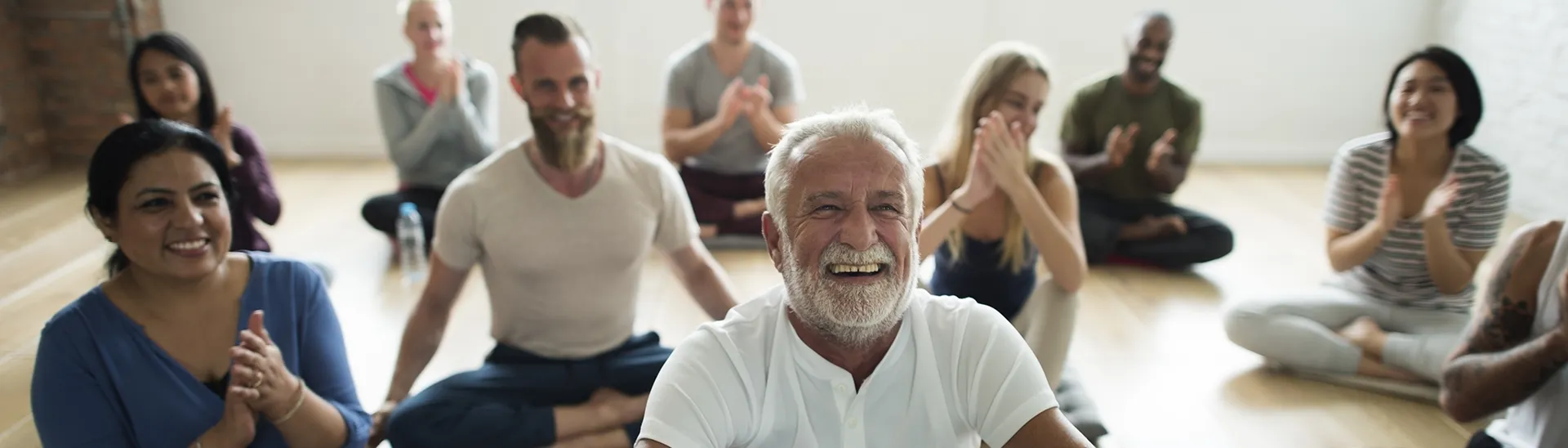 A diverse group of men and women at a yoga classes, practicing wellness.